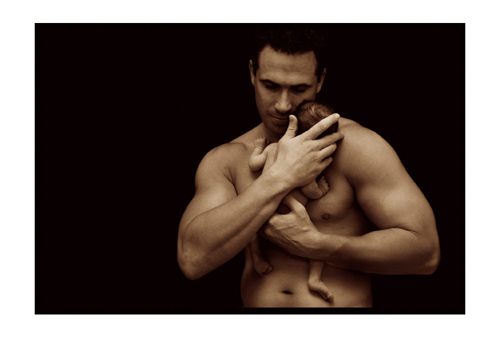 Infant in the arms of a muscular man