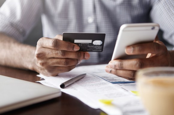 Close-up View Of African Man's Hands Holding Plastic Credit Card